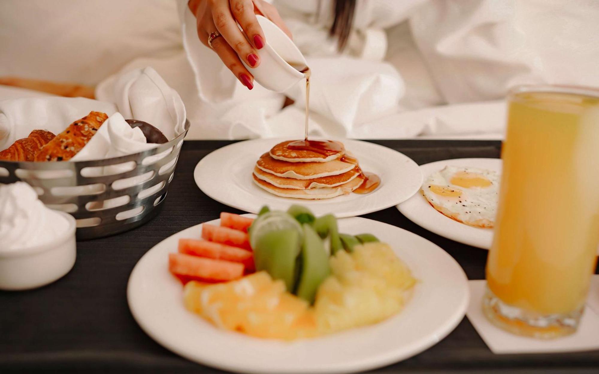 Radisson Blu Hotel Amritsar Exteriér fotografie A woman pouring maple syrup on a stack of pancakes